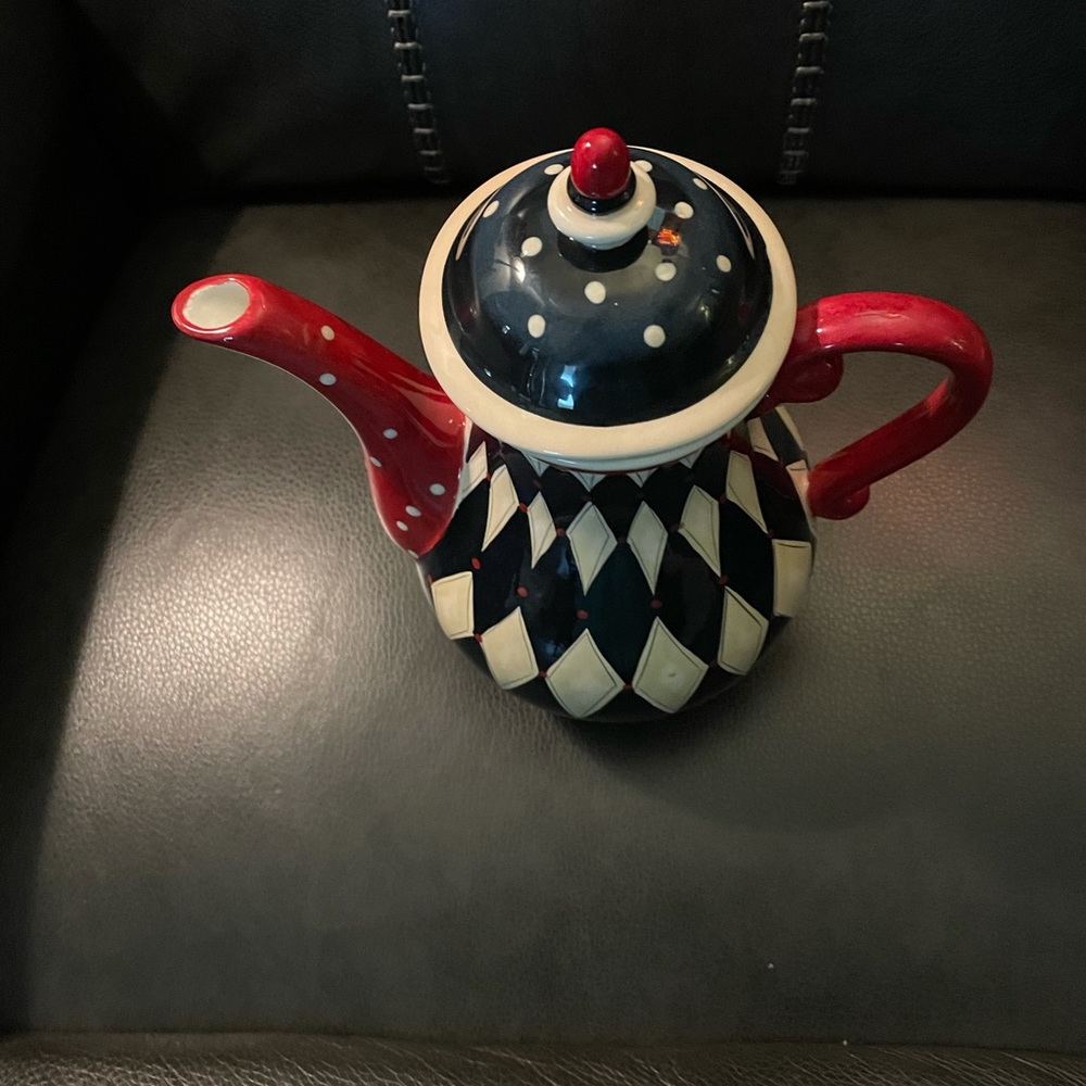 A beautiful tea pot in colors of red, black,cream